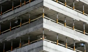 Budowa budynku z betonowymi stropami i zbrojeniem narożników wieńca, podparte tymczasowymi podporami.