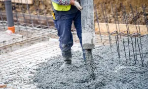 Robotnik wylewa beton na zbrojenie. Różne rodzaje betonu są kluczowe dla wytrzymałości konstrukcji.