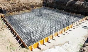 Siatka zbrojeniowa ławy fundamentowej w wykopie, przygotowana do zalania betonem.