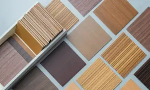 Próbki oklein drewnianych i paneli HDF w różnych odcieniach i wzorach, ułożone na szarym tle.