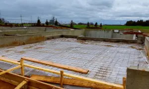 Fundamenty domu w budowie, zbrojenie gotowe do zalania betonem. Czekamy, aż ile muszą odstać fundamenty, by można było kontynuować budowę.