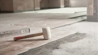 Młotek gumowy i poziomica na świeżo ułożonych płytkach. Czekamy aż beton wyschnie, by dokończyć remont.