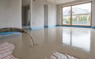 Wylewanie płynnego jastrychu na matę grzewczą w nowym domu.