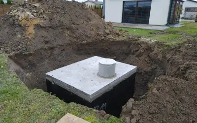 Zbiornik na deszczówkę w wykopie, przygotowywany do zakopania. Ekologiczne zbieranie deszczówki to przyszłość.