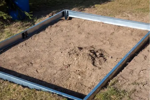 Metalowa rama wyznacza teren pod przyszłą szklarnię. To prosty sposób na zrobienie fundamentu pod szklarnię.