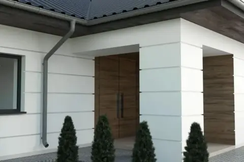 Nowoczesny dom z białymi boniami, drewnianymi drzwiami i czarnym dachem.