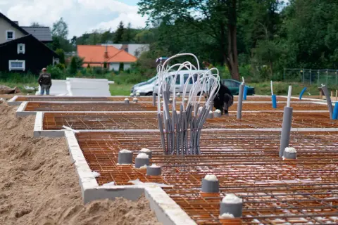 Budowa fundamentów: zbrojenie, rury i izolacja.