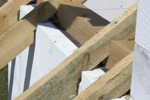 Drewniana konstrukcja dachu z elementami białego betonu komórkowego. To właśnie murłata, co to jest? To belka opierająca się na ścianie szczytowej.