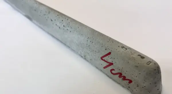 Szary, betonowy element z widocznymi pęcherzykami powietrza, oznaczony czerwonym markerem "4cm". To dystanse do zbrojenia betonowego.