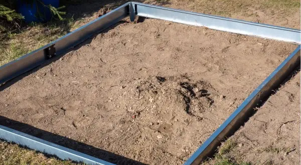 Metalowa rama wyznacza teren pod przyszłą szklarnię. To prosty sposób na zrobienie fundamentu pod szklarnię.