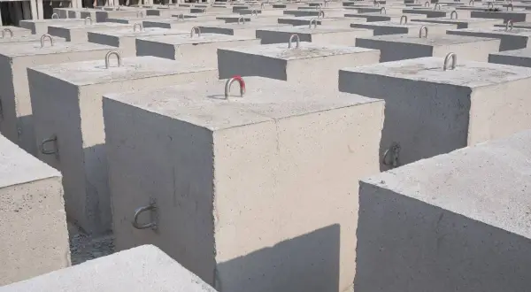 Betonowe bloki z uchwytami, gotowe do transportu. Zastanawiasz się, ile waży kubik betonu?