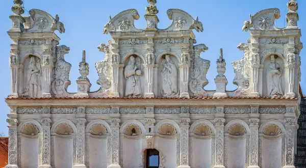 Bogato zdobiona attyka z rzeźbami i ornamentami, przykład renesansowej architektury. Co to jest attyka? To nadbudowa nad głównym gzymsem budynku.