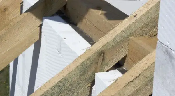 Drewniana konstrukcja dachu z elementami białego betonu komórkowego. To właśnie murłata, co to jest? To belka opierająca się na ścianie szczytowej.