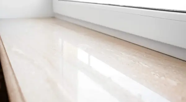 Eleganckie parapety wewnętrzne z konglomeratu w jasnym odcieniu, z subtelnym wzorem, idealnie komponują się z białym oknem.