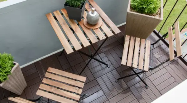 Drewniane deski na balkonie tworzą przytulną przestrzeń. Idealne, by zastanowić się, czym wyłożyć balkon, tworząc miejsce do relaksu.