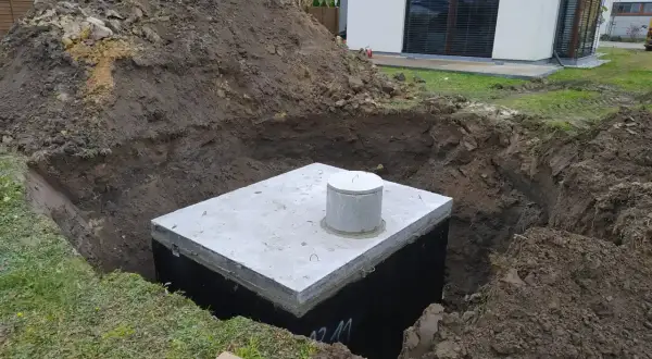 Zbiornik na deszczówkę w wykopie, przygotowywany do zakopania. Ekologiczne zbieranie deszczówki to przyszłość.