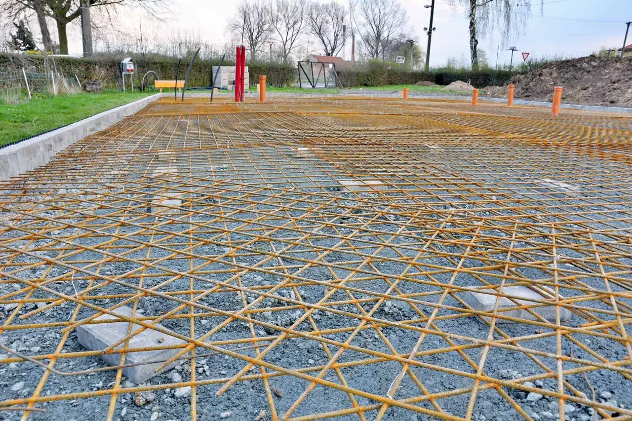 Siatka zbrojeniowa do wylewek, przygotowana pod betonowanie. Widoczne elementy instalacji i podparcia.