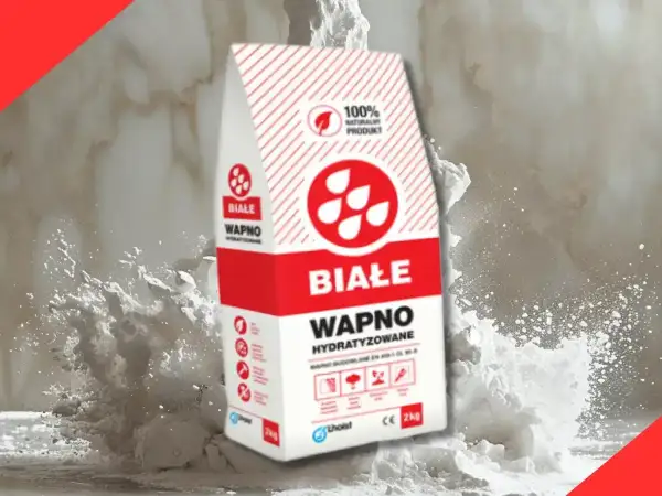 Białe wapno hydratyzowane w opakowaniu, otoczone chmurą białego pyłu. Idealne do prac budowlanych.