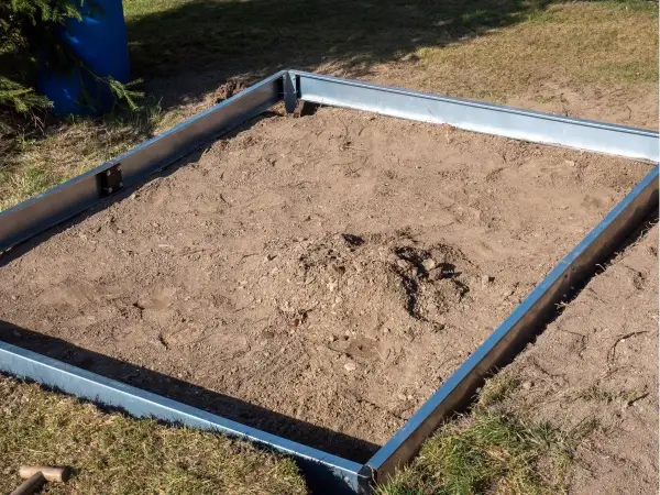 Metalowa rama wyznacza teren pod przyszłą szklarnię. To prosty sposób na zrobienie fundamentu pod szklarnię.