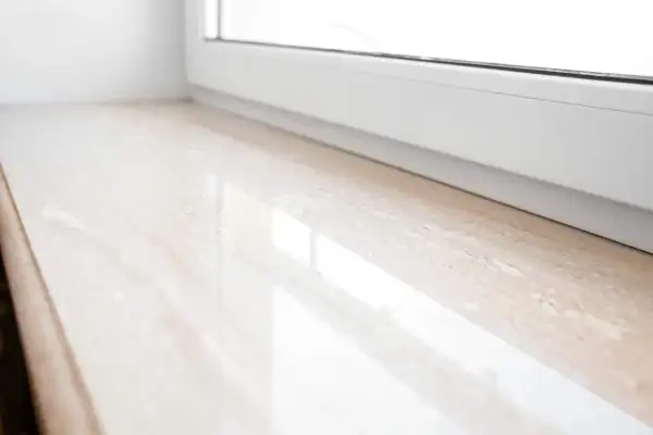 Eleganckie parapety wewnętrzne z konglomeratu w jasnym odcieniu, z subtelnym wzorem, idealnie komponują się z białym oknem.