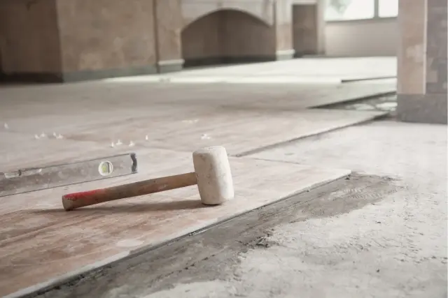 Młotek gumowy i poziomica na świeżo ułożonych płytkach. Czekamy aż beton wyschnie, by dokończyć remont.